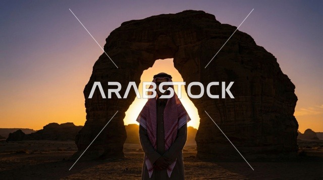رجل سعودي عند صخرة القوس في العلا وقت الغروب