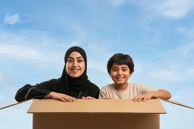 امرأة سعودية وطفل داخل صندوق كرتوني للنقل