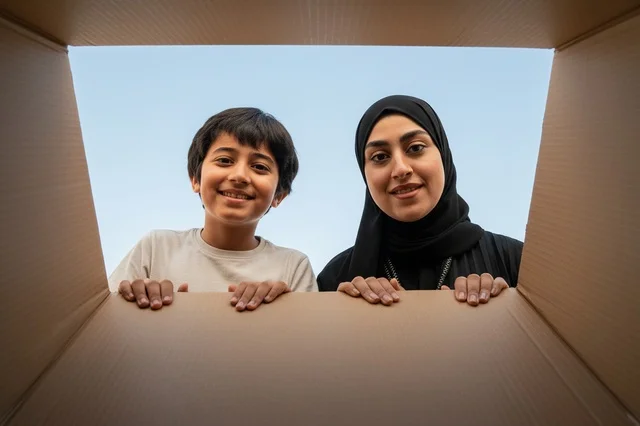 Saudi Mother and Son Unboxing Cardboard Delivery Package