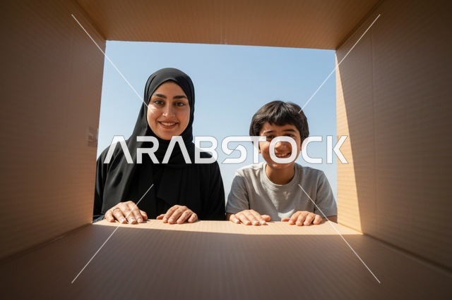 أم سعودية وابنها ينظران داخل صندوق كرتوني