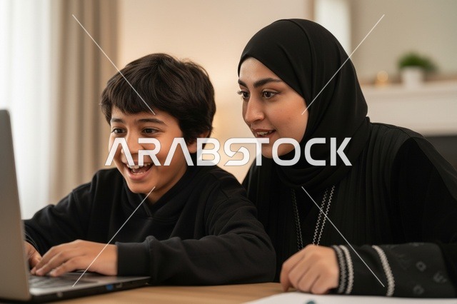امرأة سعودية وطفل يستخدمان الكمبيوتر المحمول في المنزل