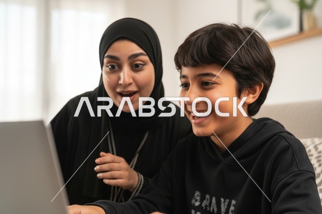 أم سعودية وابنها يستخدمان الحاسوب بتعابير مفاجأة