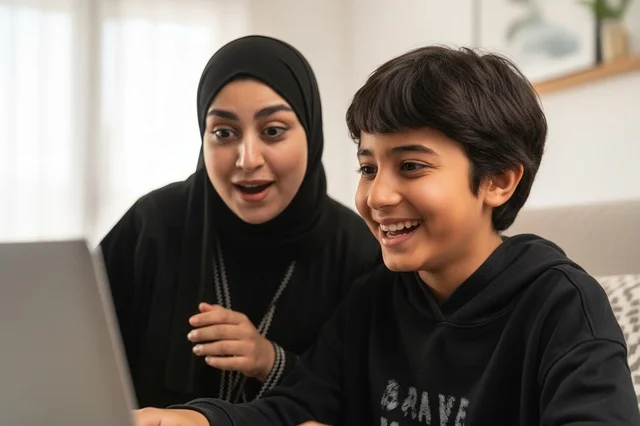 Saudi Mother and Son Using Laptop with Surprised Faces