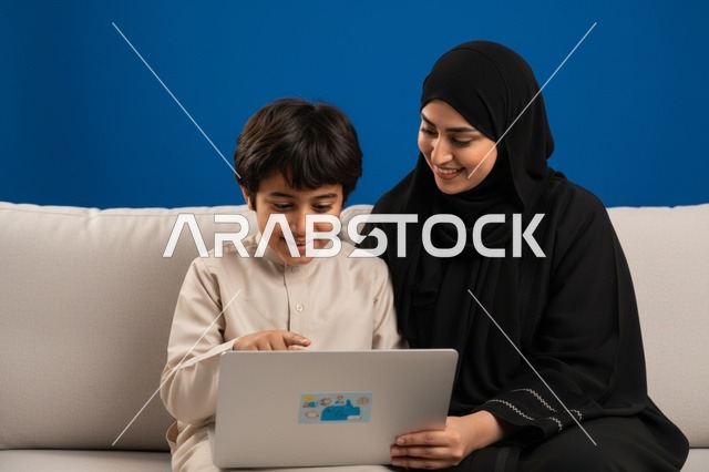 أم إماراتية وابنها يستخدمان الحاسوب المحمول