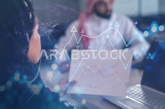 سيدة عربية سعودية خليجية محاسبة مع فريق عمل ، تستخدم جهاز الحاسوب تمسك بيدها ورقة لمخطط بياني مالي مدموجة بخلفية لرسومات بيانية لصعود و هبوط البورصة بتقنية الهولوجرام ثلاثية الأبعاد ، دراسة السوق ، اجتماعات عمل