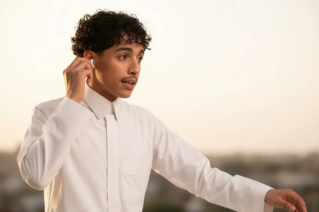 Saudi Man in White Thobe Wearing Wireless Earbuds