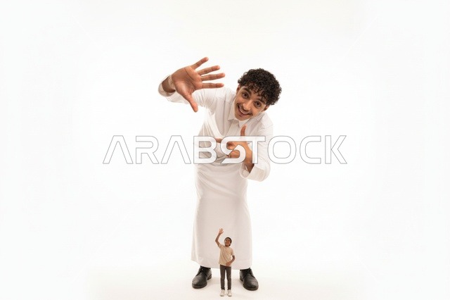 رجل سعودي بالثوب الأبيض مع مجسم صغير