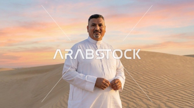 رجل سعودي بالثوب الأبيض في الصحراء وقت الغروب