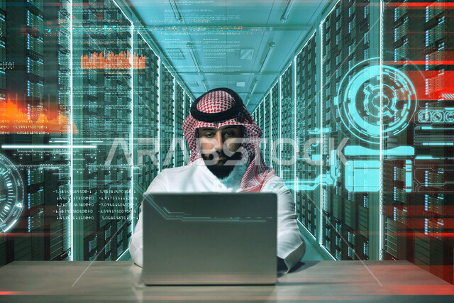 A Saudi Arabian Gulf man sitting in front of a computer, working in a data center and managing servers using the computer technical device, managing internet servers and servers, server shed, technologies and technology, data center data center