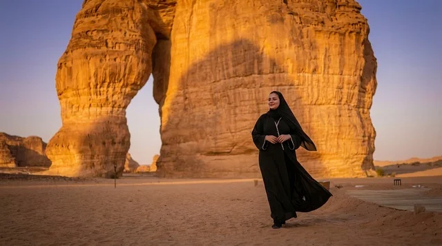 امرأة سعودية عند صخرة الفيل في العلا وقت الغروب