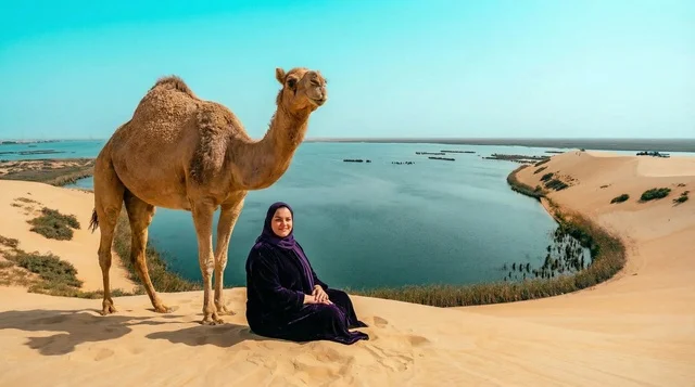 امرأة سعودية مع جمل في واحة الأحساء الصحراوية