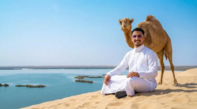 رجل سعودي مع جمل فوق كثبان رملية ساحلية