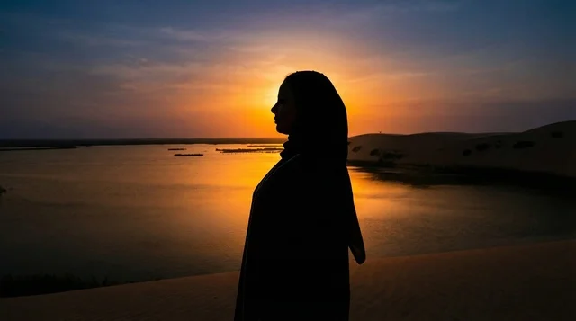 صورة ظلية لامرأة عربية عند غروب الشمس في الصحراء