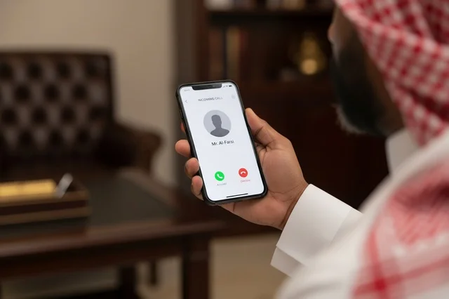 Saudi Man in Traditional Dress Holding Smartphone with Call