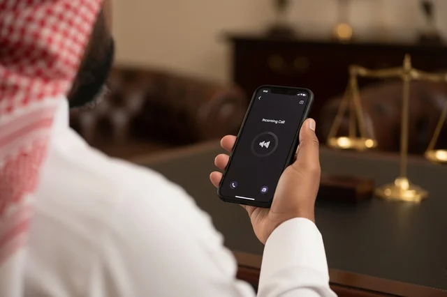 رجل سعودي مع هاتف ذكي في مكتب محاماة