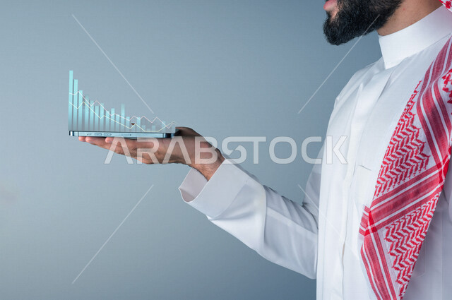 رجل عربي خليجي سعودي يحمل على كفة يده هاتف محمول ، رسم و مخطط بياني بتقنية ثلاثية الأبعاد ، متابعة سوق العملات الرقمية عن طريق الهاتف المحمول ، مراقبة صعود و نزول البورصة المالية ، الاستثمار و التداول في البورصة ، الاقتصاد والنمو المالي ، خلفية رمادية