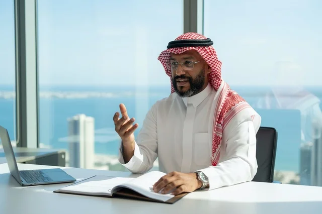 Saudi Businessman in Traditional Thobe at Office Desk