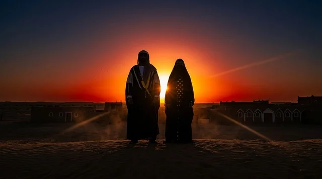 Saudi Man and Woman in Desert Silhouette at Sunset