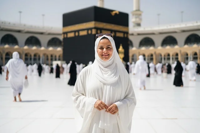 امرأة عربية مبتسمة أمام الكعبة في مكة المكرمة