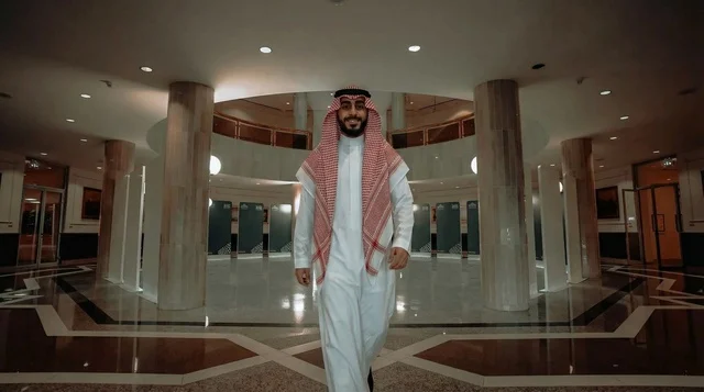 A Saudi man in the library in traditional attire.