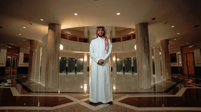 رجل سعودي بالزي التقليدي في قاعة رخامية حديثة
