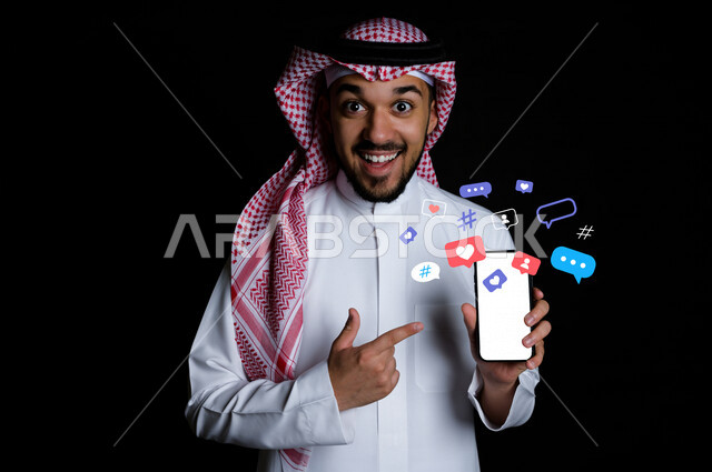 صورة لرجل عربي سعودي خليجي يقوم بإستخدام هاتفه المحمول , مجموعة من الفقاعات تحتوي على التعابير والتفاعلات , دردشة ومحادثات , تسلية وترفيه , تعارف وصداقات عبر تطبيقات التواصل الإجتماعي . 
