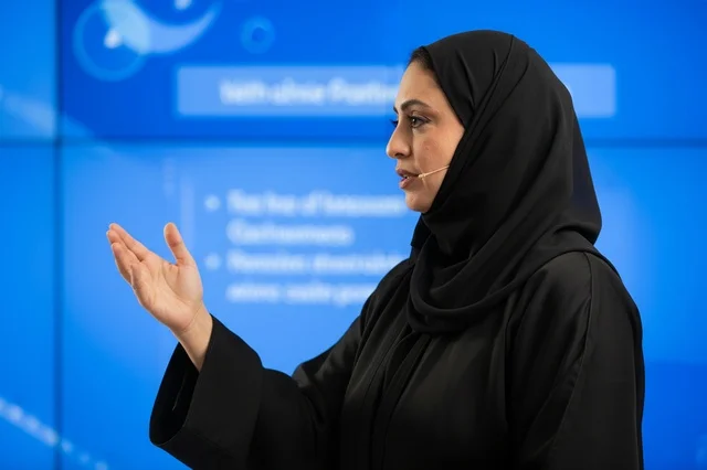 امرأة إماراتية تتحدث في عرض تقديمي في مؤتمر أعمال