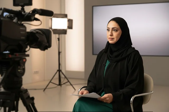 مذيعة أخبار إماراتية في استوديو تلفزيون احترافي