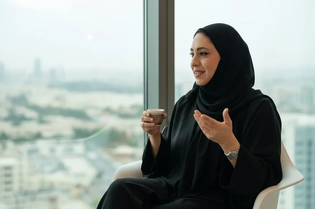 Emirati Woman in Black Abaya Holding Coffee Cup
