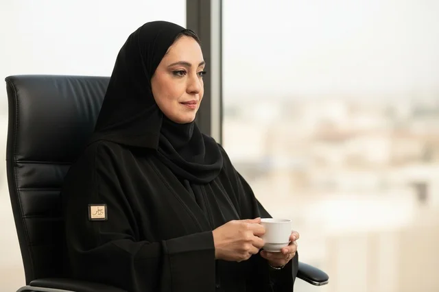 Saudi Businesswoman in Abaya Drinking Coffee in Office
