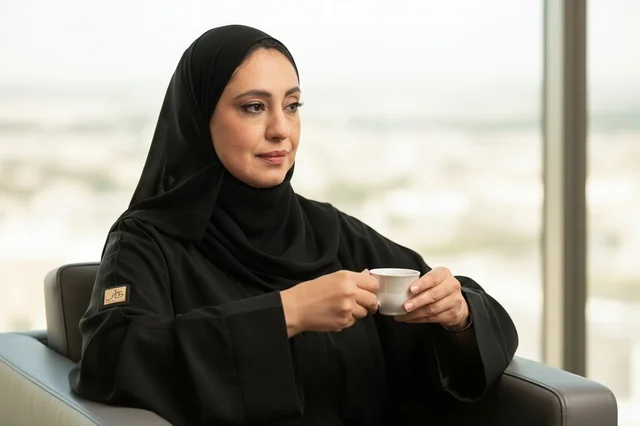 Emirati Woman in Black Abaya Drinking Coffee in Office