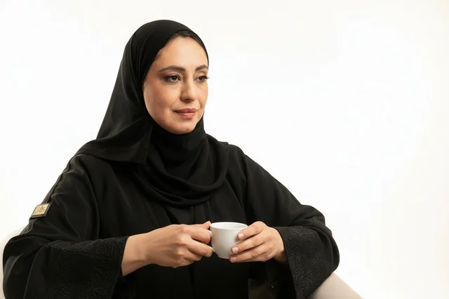 Emirati Woman in Abaya Holding Arabic Coffee Cup