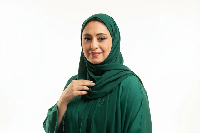 امرأة سعودية بالعباءة الخضراء والحجاب التقليدي