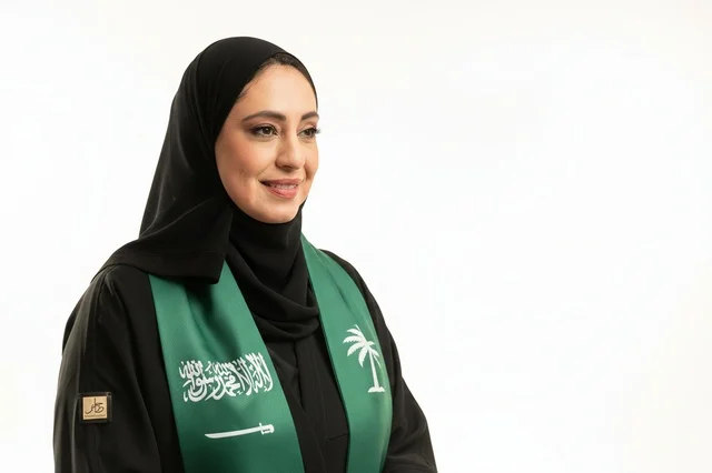 امرأة سعودية بوشاح اليوم الوطني على خلفية بيضاء