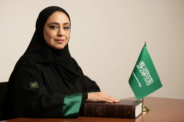 Saudi Woman Lawyer in Office with National Flag