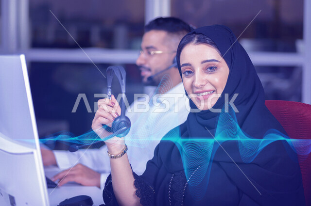 موظفان عربيان خليجيان سعوديان يعملان في خدمة العملاء، موظفة تحمل بيدها سماعة الاتصال ، الاجابه على اسئلة العملاء، متابعة وتطوير العمل ، خلفية للموجات الصوتية بتقنية الهولوجرام، تسجيل صوتي ، تقديم برنامج اذاعي 