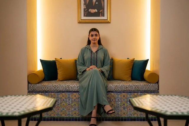Moroccan Woman in Traditional Djellaba Sitting Indoors