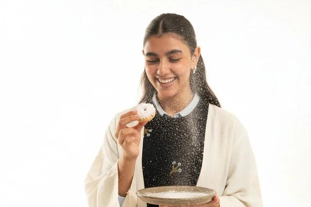 Saudi Woman in Abaya with Traditional Maamoul Cookie