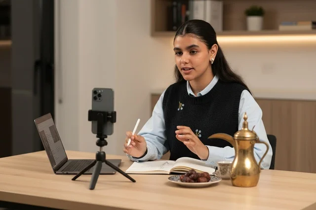 Saudi Woman Vlogging with Smartphone and Coffee