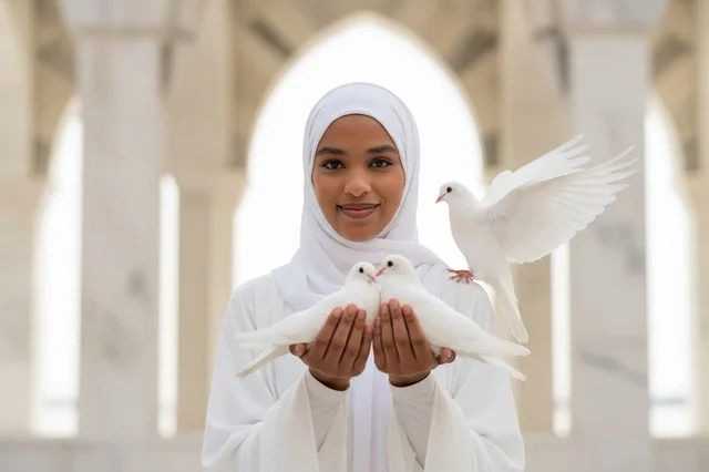 A Somali woman in a white hijab holding a white dove.