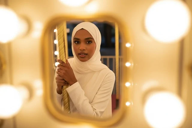 Somali Woman in White Hijab with Carousel Reflection