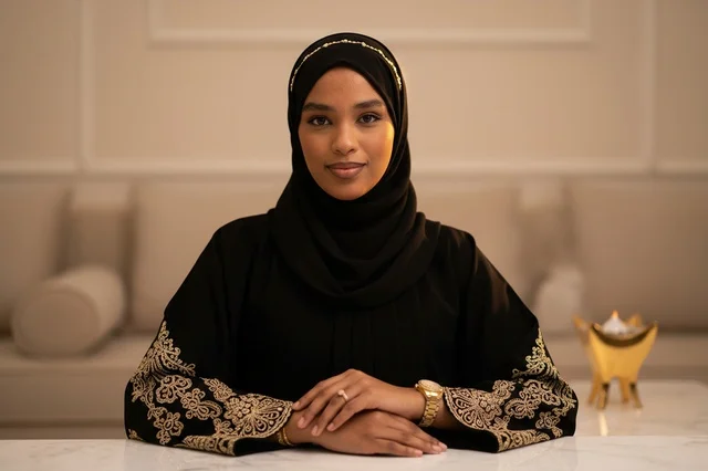An Emirati woman in a black abaya inside a modern council.
