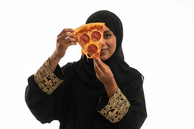 امرأة إماراتية بالعباءة تحمل شريحة بيتزا ببروني