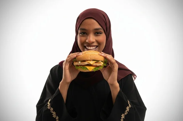 African Woman in Hijab Holding Cheeseburger