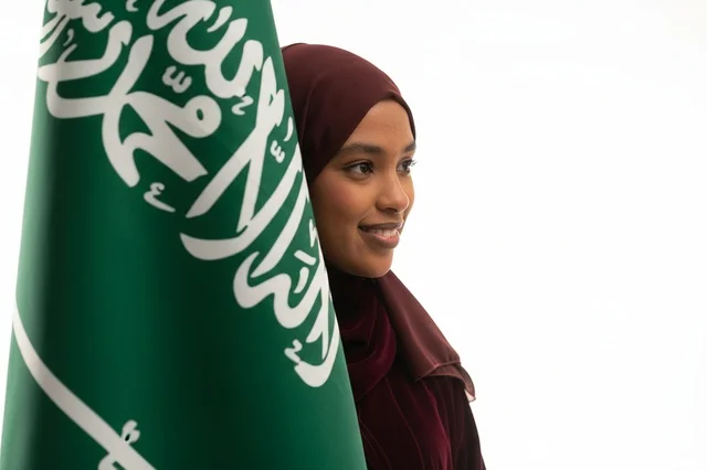 امرأة سعودية مع العلم الوطني في الاستوديو