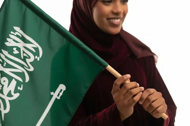 امرأة سعودية تحمل العلم الوطني للمملكة العربية السعودية