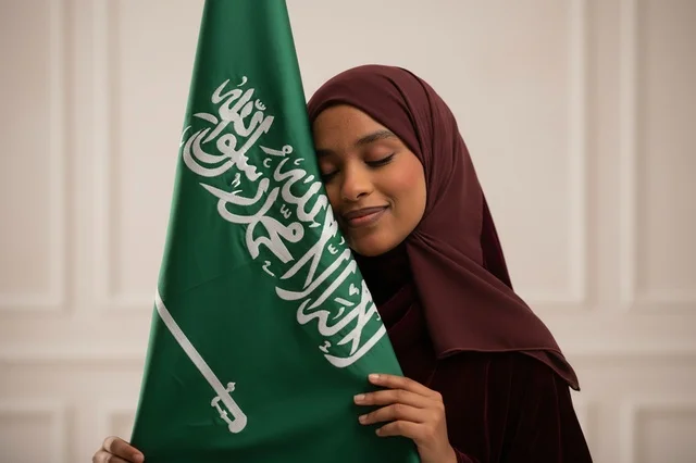 Saudi Woman with National Flag in Traditional Clothing
