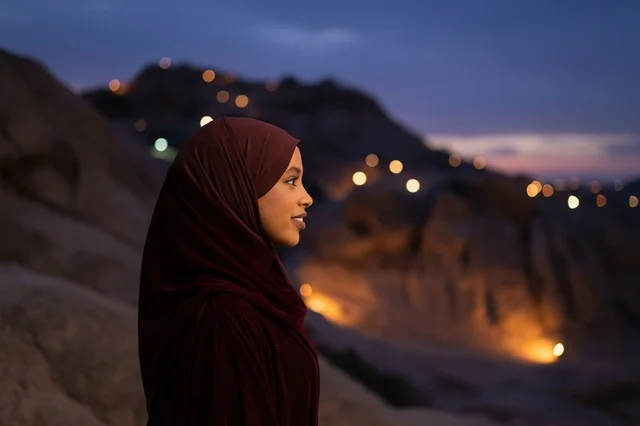 امرأة أفريقية بالحجاب العنابي في الجبال وقت المساء