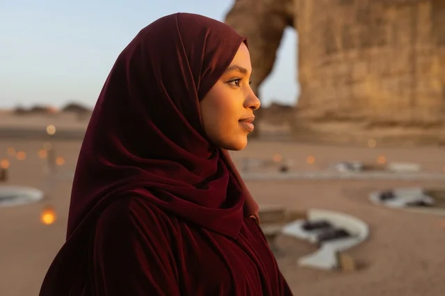 امرأة سعودية في صحراء العلا وقت الغروب