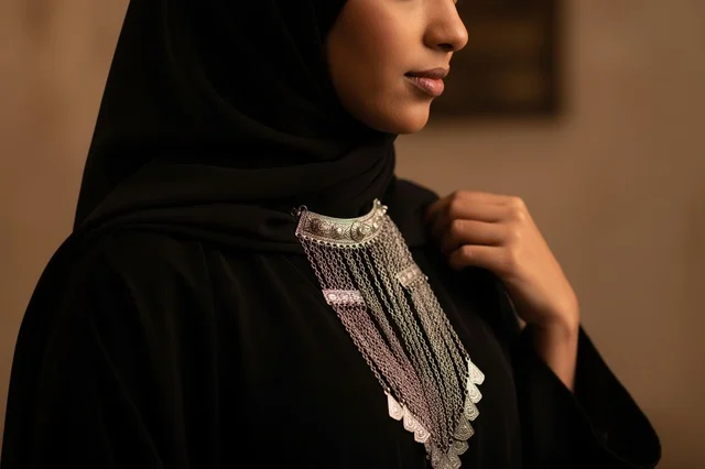 Saudi Woman in Black Abaya with Traditional Silver Necklace Saudi Woman in Black Abaya with Traditional Silver Necklace